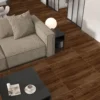 Sala espaciosa con sofá gris, mesa de centro de madera y piso de cerámica madera Arizal Café, colección Ecos de Cerámicos Gala