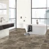 Baño iluminado con bañera blanca, ducha con recubrimiento de cristal y piso de cerámica mármol Regent Brown, colección Ecos de Cerámicos Gala