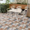 Exterior terraza, mesas blancas, reposador de madera, adornado con plantas en el borde y piso de cerámica piedra Valterra, colección Ecos de Cerámicos Gala