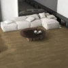 Sala amplia con sofá blanco y centro de mesa de madera oscuro que resalta el piso de cerámica madera Fauna, colección Sylva de Cerámicos Gala