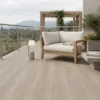Terraza mirador espaciosa, sofá de madera y cojines blancos, con un piso de cerámica madera Oyster, colección Sylva de Cerámicos Gala