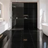 Baño moderno blanco y negro con lavamanos de mármol y piso de cerámico liso Laccio Negro, colección Materia 46x46 de Cerámicos Gala